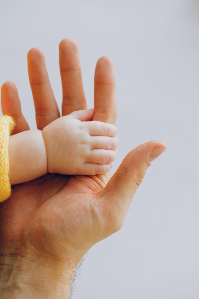 Nahaufnahme einer Babyhand in der Hand des Vaters