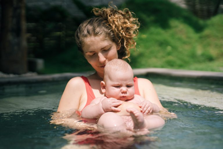 Eine Mutter mit ihrem Baby beim Babyschwimmen.